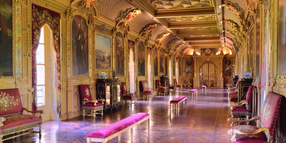 La galerie des portraits du château : enfilade dorée, grands portraits de famille, banquettes de velours et cabinets en laque.