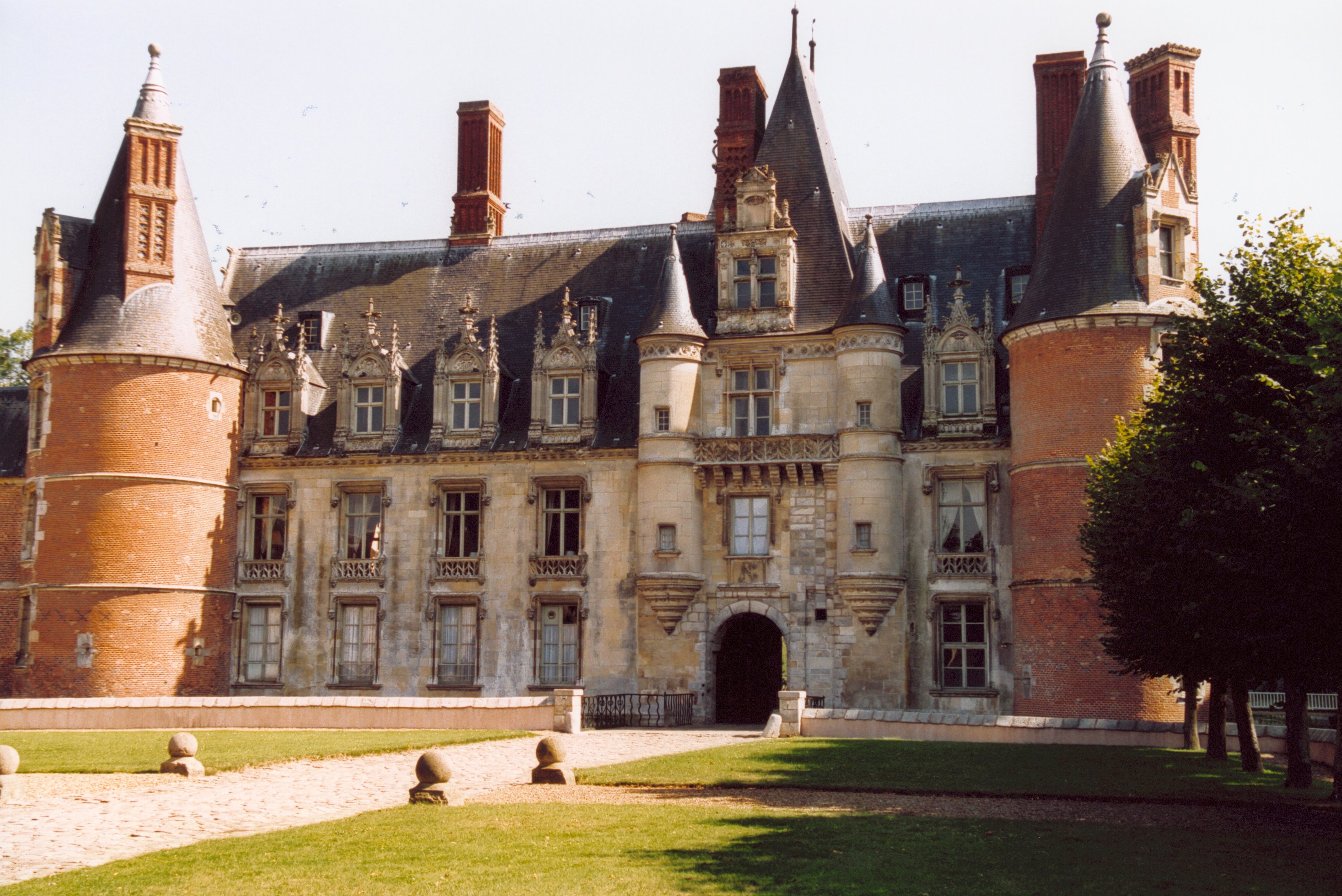 La façade du château de Maintenon côté cour : tours de brique, lucarnes sculptées et porche d'entrée.