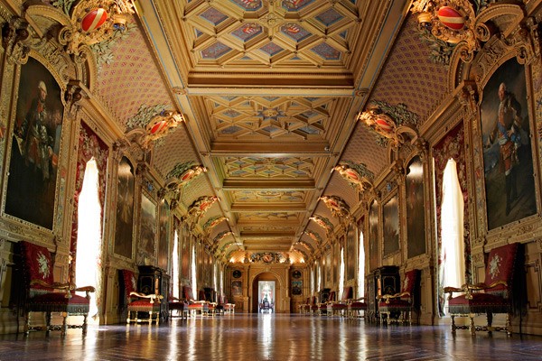 La grande galerie du château de Maintenon : plafond à caissons doré, grands portraits, fauteuils et banquettes de velours rouge.