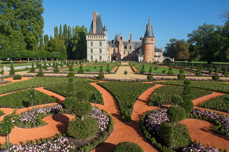 Les jardins à la française du château de Maintenon : parterres de broderie, topiaires et allées, face à la façade de brique.